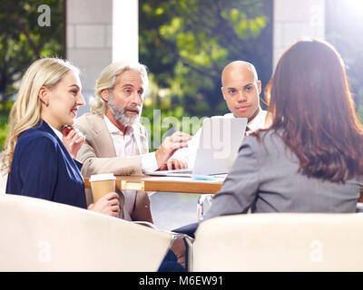 Multinationalen und multiethnischen leitende Geschäftsleute treffen in der Lobby des modernen Bürogebäude. Stockfoto