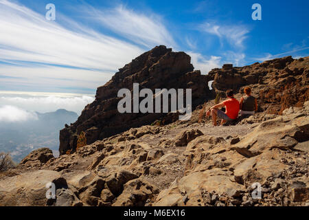 Zwei reife Touristen sitzen auf felsigen Berge der Insel Gran Canaria. Stockfoto
