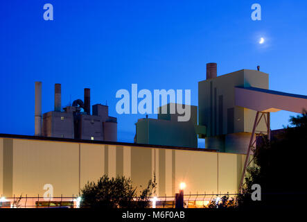 Teil eines Zementwerks in den Abend mit Mond. Stockfoto