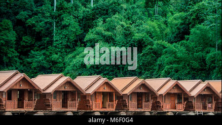 Nahaufnahme der Reihe der Bungalows aus Holz mit dem Dschungel im Hintergrund Stockfoto