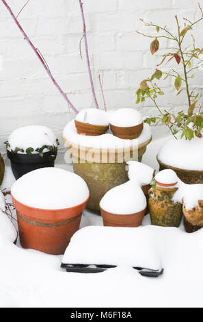 Schnee bedeckt Töpfe im Garten. Stockfoto