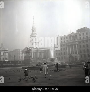 1950, historisch, am frühen Morgen und eine Mutter und ihr Kind mit den Tauben auf einem nahe verlassenen Trafalgar Square, London, England, Großbritannien, Stockfoto