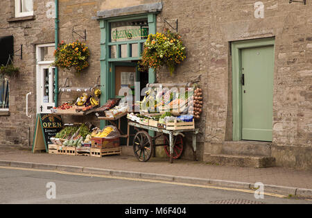 Kleiner unabhängiger Obst- und Gemüseladen, der frische Produkte von einer Schubkarre außerhalb eines Ladens in der Stadt Hay auf Wye Powys Wales UK verkauft Stockfoto