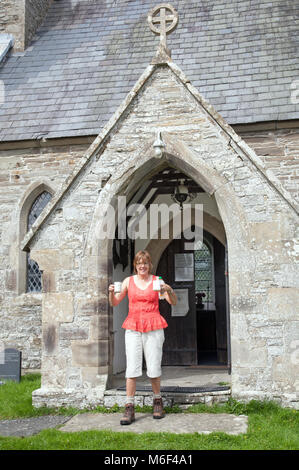 Walker gestoppt und profitieren Sie von unserer kostenlosen Getränke und Kekse an der Kirche St. Mary an der Neuen Kirche Montgomery zu nehmen, während wenige Offa's Dyke long distance Path Stockfoto