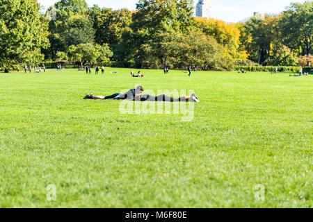 New York City, USA - Oktober 28, 2017: Manhattan NYC Central Park mit ein paar Menschen liegend mit Picknick auf der großen Wiese gras wiese im Herbst Fal Stockfoto
