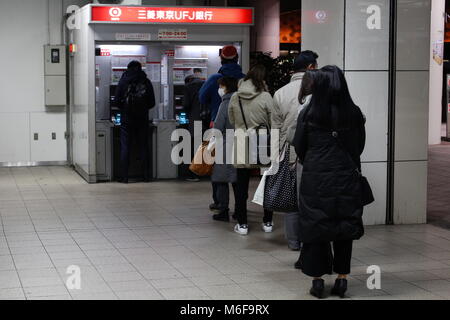 Kunden queuing Tokio Mitsubishi UFJ Geldautomaten in zentralen Chiba City zu verwenden. (22. Februar 2018:) Stockfoto