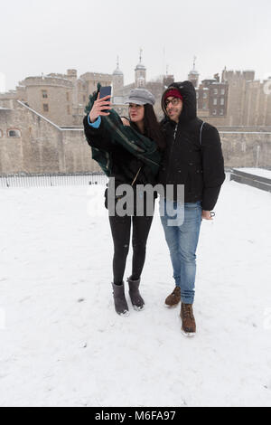 London, Großbritannien. 2. März 2018. Ein Paar aus Italien für eine selfie vor dem Tower von London während Snow Fall in London, England am 2. März 2018 wie Frost, daß das "Tier aus dem Osten' kombiniert mit Sturm Emma haben Schnee und Frost nach Großbritannien gebracht. Stockfoto
