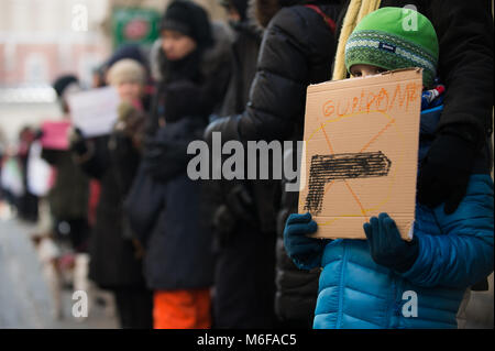 Krakau, Polen. 3 Mär, 2018. Ein Junge hält einen Banner mit einem Gewehr auf während ein stiller Protest gegen die ständigen Bombardierung von ghuta neben dem Hauptplatz in Krakau. syrische Regierung Kräfte weiterhin Bombardierung der Stadt Ghuta in Syrien, bei denen mehrere Zivilisten während der internationale Druck immer nachfragen, das Gemetzel in der Rebel Enklave zu stoppen. Credit: DHP 3677.jpg /SOPA Images/ZUMA Draht/Alamy leben Nachrichten Stockfoto