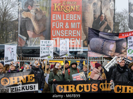 München, Deutschland. 3 Mär, 2018. Tierschützer gegen die Haltung von Zirkustieren außerhalb von "Circus Krone" in München, Deutschland, 3. März 2018 demonstrieren. Hinter der Masse hängt eine orange Fahne auf die Mitarbeiter der Circus" für ein Leben mit Tieren befürworten. Rund 1.000 Menschen versammelt, um zu protestieren. Credit: Matthias Balk/dpa/Alamy leben Nachrichten Stockfoto