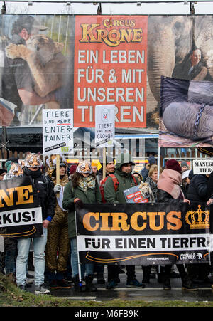 München, Deutschland. 3 Mär, 2018. Tierschützer gegen die Haltung von Zirkustieren außerhalb von "Circus Krone" in München, Deutschland, 3. März 2018 demonstrieren. Hinter der Masse hängt eine orange Fahne auf die Mitarbeiter der Circus" für ein Leben mit Tieren befürworten. Rund 1.000 Menschen versammelt, um zu protestieren. Credit: Matthias Balk/dpa/Alamy leben Nachrichten Stockfoto