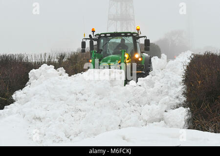 Compton Valence, Dorset, Großbritannien. 3. März 2018. UK Wetter. Eine Fremdfirma mit Traktor und Digger attachment Löschen des letzten der Straßen gesperrt durch Schneeverwehungen von Strom Emma auf Eggardon Hill in der Nähe von West Compton in Dorset. Ist der Schnee zu tauen beginnt mit die meisten Felder fast Schnee frei, aber die Drifts entlang der Straßen und Plätze sind 4-5 Meter hoch. Foto: Graham Jagd Fotografie Credit: Graham Jagd-/Alamy leben Nachrichten Stockfoto