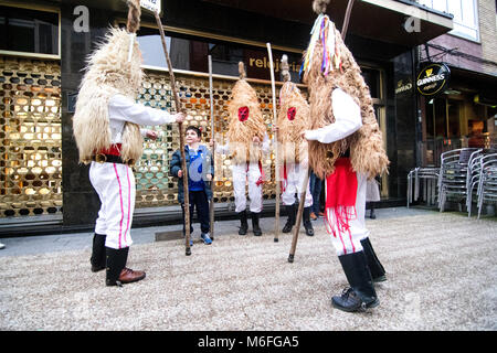 Benalmádena, Spanien. 3. März, 2018. Einige sidros, eine traditionelle Maske von Valdesoto (Asturien, Spanien), spielen mit einem Kind während Mazcaraes d'Iviernu, einer iberischen Maske Festival feierte am 3. März in Gijón, Asturien, Spanien 2018. Iberischen Masken oder Winter Masken sind traditionelle Feste der Stadt von Portugal und Spanien zum keltischen Kulten, wo die Menschen mit Masken, Felle und Lumpen getarnt sind miteinander verknüpft. © David Gato/Alamy leben Nachrichten Stockfoto