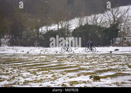 Radfahrer im Schnee Hadleigh Country Park während des Tieres aus dem Osten wetter Phänomen. Schneebedecktes Feld. Olympischen Mountainbike Kurs 2012 Stockfoto