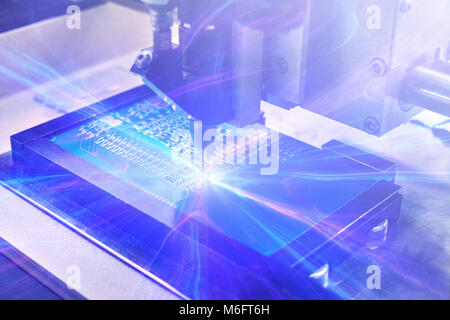 Das Konzept der Technologien der Zukunft. Computer Board mit visuellen Effekten in einem futuristischen Stil. Automatisierung der Zusammenbau der Maschine der Computerplatine. Der Prozess der Löten der Platine. Stockfoto