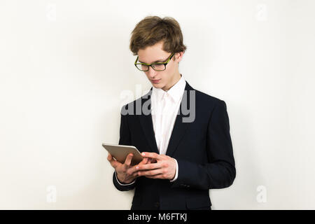 Junge erfolgreiche und selbstbewusste Business männliche Person Kontrolle Nachrichten oder Informationen in Tablet-PC. Stockfoto