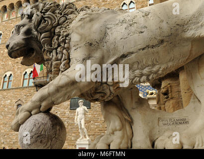 Statue eines Löwen in der Loggia dei Lanzi Piazza della Signoria und Michelangelos Skulptur des David vor dem Palazzo Vecchio Hintergrund Kopie ich Stockfoto