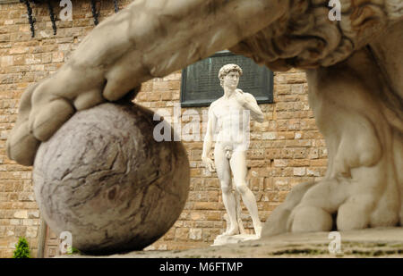 Statue eines Löwen in der Loggia dei Lanzi Piazza della Signoria und Michelangelos Skulptur des David vor dem Palazzo Vecchio Hintergrund Kopie ich Stockfoto