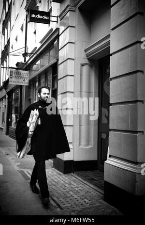 Mann in einem Cape, entlang Berwick Street, Soho, London, England, UK; Stockfoto