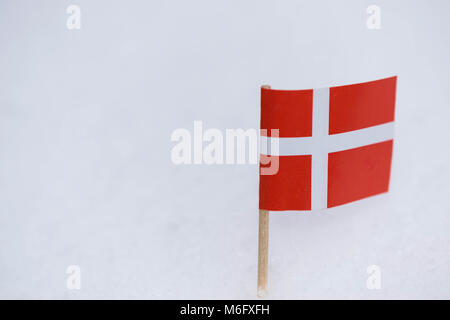 Dänemark Flagge aus Papier mit braunen Zahnstocher auf weißem Schnee Hintergrund. Stockfoto