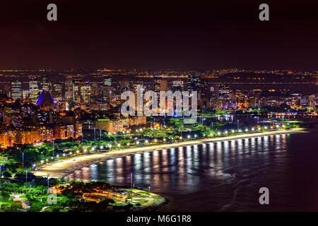 Nacht Blick auf die Spitze des Rio de Janeiro Innenstadt mit den Lichtern der Stadt, Gebäude, Strand und Straßen in einer Sommernacht Stockfoto