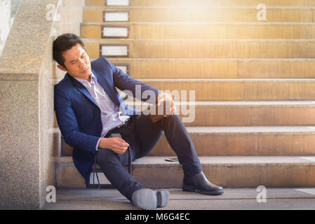 Traurig Geschäftsmann sitzen auf Schritte außerhalb der. Stockfoto