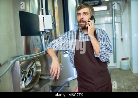 Bärtige Techniker mit Handy Stockfoto