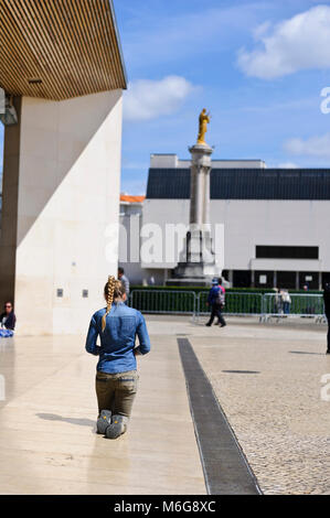 Eine junge weibliche Anhänger langsam auf die Knie im Heiligtum von Fatima, Portugal Stockfoto