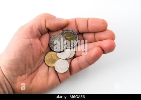 Einige thailändische Münzen auf einer Hand Stockfoto