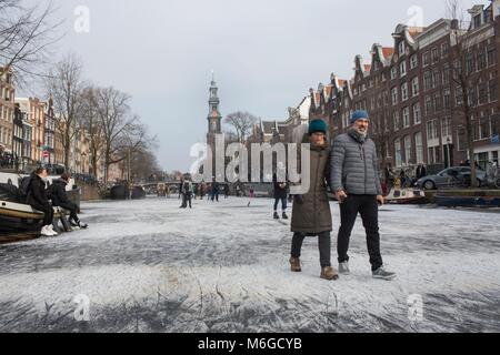 Eislaufen auf den Grachten von Amsterdam. Der letzte Zeitpunkt, zu dem die Kanäle eingefroren wurden, war im Februar 2015. Stockfoto