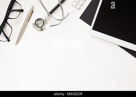 Ärzte Büro Schreibtisch mit digitalen Tablet mit Stethoskop und Brillen Stockfoto