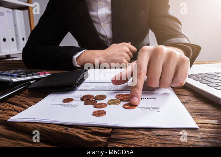 Der Unternehmer Hand Zählen von Münzen mit der Brieftasche und Bill auf hölzernen Schreibtisch Stockfoto