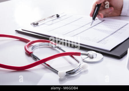 Nahaufnahme einer Stethoskop in der Nähe des Doctor's Hand Analyse Bericht über die Zwischenablage Stockfoto