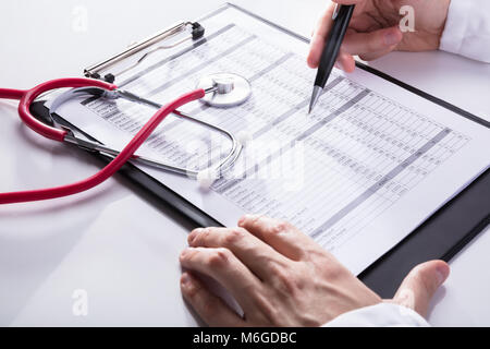 Nahaufnahme einer Stethoskop in der Nähe des Doctor's Hand Analyse Bericht über die Zwischenablage Stockfoto
