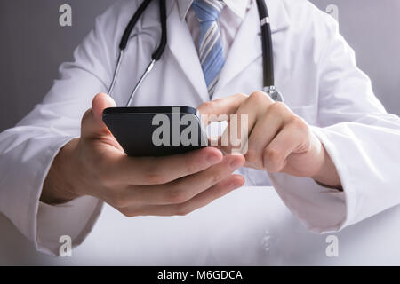 In der Nähe von einem Arzt Hand mit Smartphone in der Klinik Stockfoto