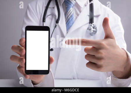 In der Nähe von einem Arzt Hand zeigt leere weiße Mobile Bildschirm Stockfoto