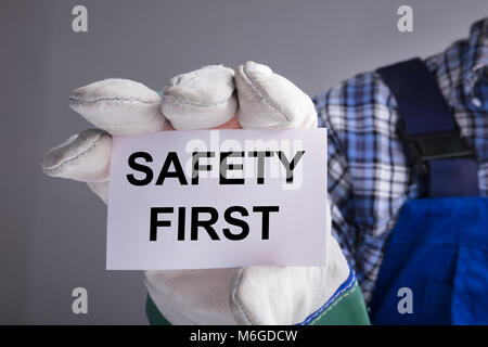 Close-up des Arbeiters Hände mit Handschuhen mit Sicherheit erstes Zeichen Stockfoto