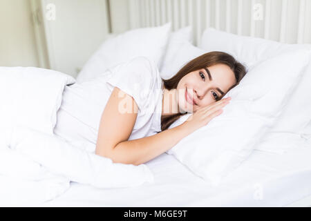 Eine zufrieden schlafen auf der Seite junge Frau sanft lächelnd im Bett Stockfoto
