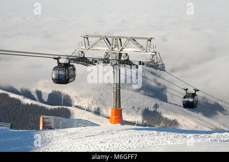 CHOPOK, SLOWAKEI - Dezember 13, 2017: Seilbahnen rauf und runter im Winter sports Resort, an einem sonnigen Tag - Jasna, Chopok, Slowakei Stockfoto