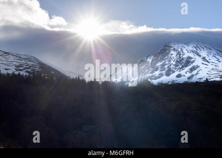 Die Sonne bricht durch die Wolke über die Nordwand des Ben Nevis an einem Wintertag in den Highlands von Schottland, Großbritannien. Stockfoto