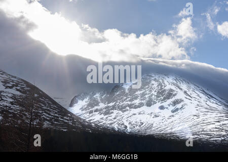 Die Sonne bricht durch die Wolke über die Nordwand des Ben Nevis an einem Wintertag in den Highlands von Schottland, Großbritannien. Stockfoto