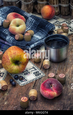 Zubehör Picknick bestehend aus Pfirsiche, Äpfel und Lottospiele. Foto getönt. Stockfoto