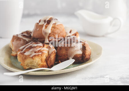 Hausgemachte Zimtkuchen in Glasur auf einem leichten, hellen Hintergrund, Kopieren, Ansicht von oben. Stockfoto