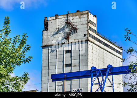 Silogebäude aus Beton mit Feuerleiter auf weißer Fassade vor blauem Himmel Stockfoto