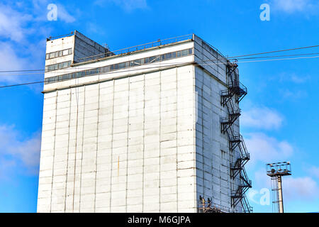 Silogebäude aus Beton mit Feuerleiter auf weißer Fassade vor blauem Himmel Stockfoto