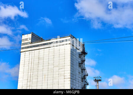 Silogebäude aus Beton mit Feuerleiter auf weißer Fassade vor blauem Himmel Stockfoto