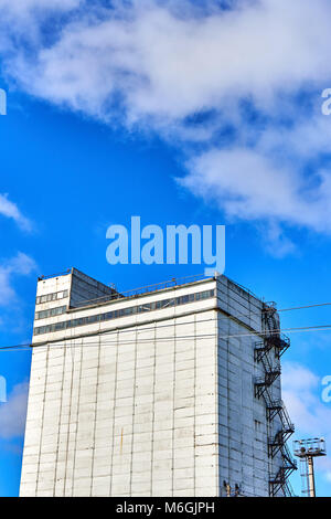 Silogebäude aus Beton mit Feuerleiter auf weißer Fassade vor blauem Himmel Stockfoto