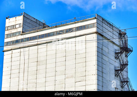 Silogebäude aus Beton mit Feuerleiter auf weißer Fassade vor blauem Himmel Stockfoto