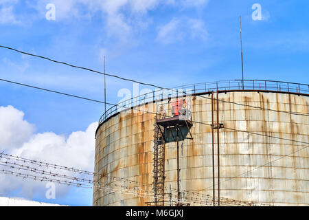 Alte rostige Industrietankanlage vor blauem bewölktem Himmel Stockfoto