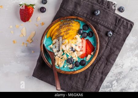 Berry Smoothie Schüssel mit Mango und Kokos, Ansicht von oben. Vegan Gesunde Ernährung Konzept. Stockfoto