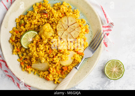 Curry Bulgur mit Gemüse in einem weißen Teller. Gesunde vegane Ernährung Konzept. Stockfoto